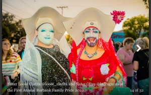 Figure 13. Image description: Sister Unity at Dragcon in 2018 where she spoke on the Sisters’ panel. Photograph of a person in an all-orange costume and elaborate makeup against a light gray background.