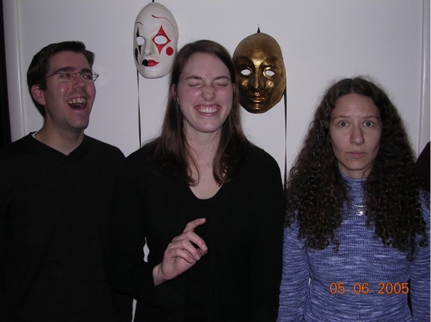 Figure 3: A wall with two masks. In front young Scot and Ashley laughing and Jennifer with a bewildered eyes-wide expression. Date stamp 05 06 2005