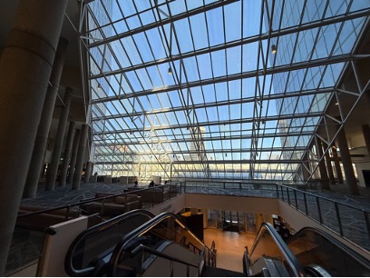 Figure 2.2: An architectural image of a steel reinforced window that slopes down from the top of the image to the bottom over an escalator leading to a lower lobby.